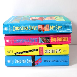 May include: A stack of four paperback books with colorful covers. The books are titled "My Spy", "Hot Pursuit", "Code Name: Baby", and "Code Name: Nanny" by author Christina Skye. The covers are in shades of blue, pink, and yellow.