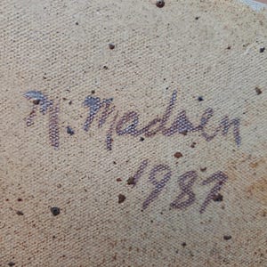 K&ouml;nnte beinhalten: Nahaufnahme einer strukturierten, beigefarbenen Oberfl&auml;che mit der handschriftlichen Signatur "N. Madsen" und dem Jahr "1987" in Dunkelbraun. Die Oberfl&auml;che hat kleine, dunkelbraune Sprenkel.