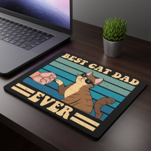 Peut inclure: Un tapis de souris noir avec un design rétro représentant un chat portant des lunettes de soleil et le texte "Best Cat Dad Ever".