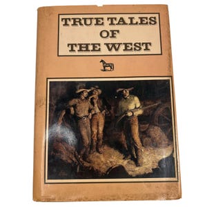 May include: A vintage book titled "True Tales of the West" with a tan cover. The cover features a framed illustration of three men in cowboy hats, one holding a rifle. A horse silhouette is above the illustration.