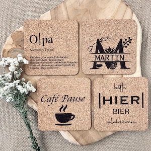 Könnte beinhalten: Vier Korkuntersetzer mit verschiedenen Designs. Der erste Untersetzer sagt "Olpa" und hat eine Definition des Wortes. Der zweite Untersetzer hat einen großen Buchstaben "M" mit dem Namen "Martin" darunter. Der dritte Untersetzer sagt "Cafe Pause" mit einem Kaffeetassen-Symbol. Der vierte Untersetzer sagt "bitte HIER BIER platzieren".