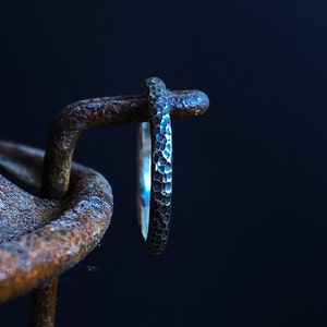 Narrow black stacking ring with milled pattern made of silver, stone look