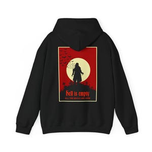 May include: Black hoodie featuring a graphic on the back with a red background, a yellow moon, and a silhouette of a figure with the text "Hell is empty, all the devils are here."