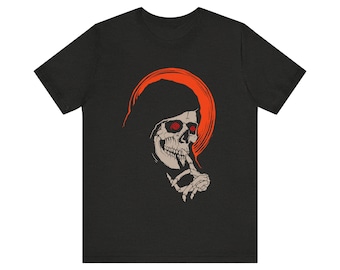 May include: Black t-shirt featuring a graphic of a skull with red eyes and an orange halo. The skull is depicted with a finger pressed to its lips, suggesting silence. The design is a bold, minimalist illustration.