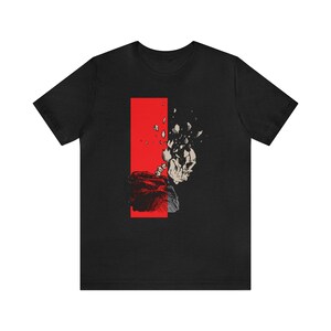 May include: Black t-shirt with a graphic of a skull breaking apart with a red background.