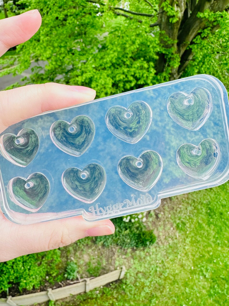 May include: Clear plastic mold with eight heart-shaped cavities. The mold is labeled "Hygge Mold".