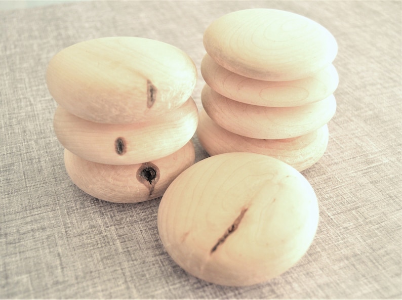Puede incluir: Una pila de cinco c&iacute;rculos de madera natural, cada uno con un patr&oacute;n de veta ligeramente diferente. Los c&iacute;rculos son lisos y tienen un color de madera claro y natural.