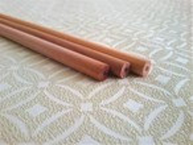 May include: Three wooden dowels of varying lengths and diameters. The dowels are natural wood colour and have a smooth, polished finish.