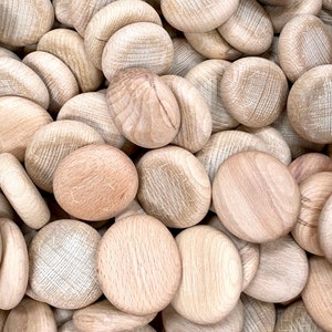 Puede incluir: Primer plano de una pila de discos de madera lisos de color marr&oacute;n claro. Los discos son todos de tama&ntilde;o y forma similares, y est&aacute;n dispuestos en un patr&oacute;n aleatorio.