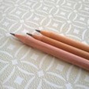 May include: Three wooden pencils with black graphite leads. The pencils are unsharpened and have a natural wood finish.