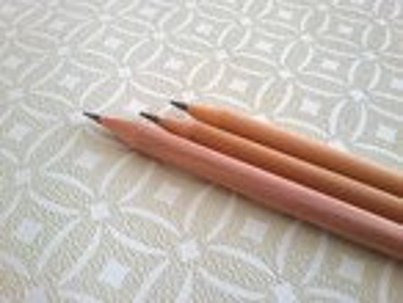May include: Three wooden pencils with black graphite leads. The pencils are unsharpened and have a natural wood finish.