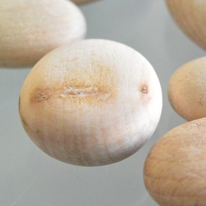 Puede incluir: Un conjunto de cinco huevos de madera lisos de color marr&oacute;n claro. Los huevos son ligeramente ovalados y tienen una veta de madera natural.