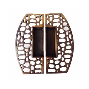 May include: A pair of antique brass door handles with a unique, intricate, and organic design. The handles are made of solid metal and have a smooth, polished finish.