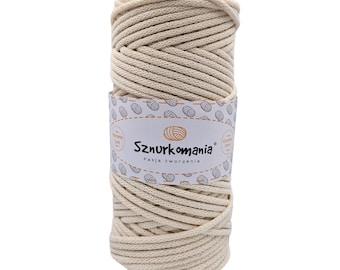 May include: A roll of natural coloured cotton rope, ideal for crafting. The rope is wound around a cardboard tube and has a label that reads "Sznurkomania Pasja tworzenia".