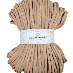 May include: A large spool of beige cotton cord, perfect for crafting. The cord is wound tightly and has a smooth texture. The label on the spool reads "Sznurkomania Pasja tworzenia".