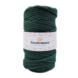 Può includere: Un rotolo di cordoncino di cotone verde scuro, etichettato "Sznurkomania Pasja tworzenia" con un logo di un gomitolo di lana stilizzato.