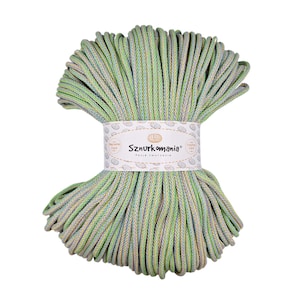 Puede incluir: Un ovillo de cordón de algodón verde, azul y beige, con una etiqueta que dice "Sznurkomania Pasja tworzenia" (Pasión por la creación).