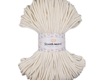 May include: A large spool of natural white cotton cord, ideal for crafting projects. The cord is wrapped around itself and has a label that reads "Sznurkomania Pasja tworzenia".