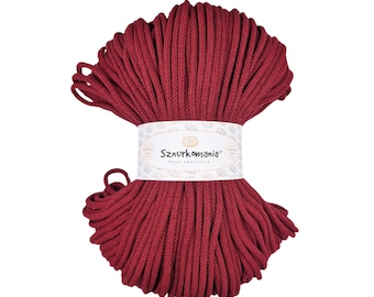 May include: A spool of deep red cotton cord, wrapped in a spiral shape. The cord is labelled "Sznurkomania" with the text "Pasja Tworzenia".