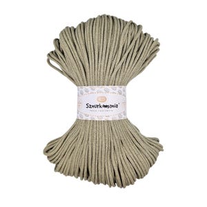May include: A spool of beige cotton cord, wrapped in a white label with the text "Sznurkomania" in brown lettering. The label also includes a small image of a ball of yarn.