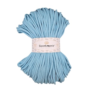 Puede incluir: Un ovillo de cordón de algodón azul claro, perfecto para macramé o proyectos de manualidades. El cordón está envuelto alrededor de una etiqueta que dice "Sznurkomania Pasja tworzenia".