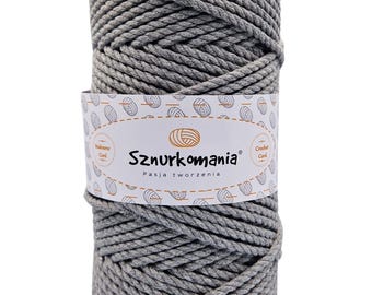 Pode incluir: Um cordão de corda de algodão cinza, enrolado em uma bola, com um rótulo branco que diz "Sznurkomania Pasja tworzenia" e "Macrame Cord" e "Crochet Cord".