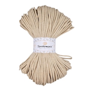 May include: A beige cotton cord, wound into a coil, with a white label that reads "Sznurkomania Pasja tworzenia".