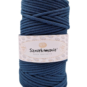 Puede incluir: Un carrete de cordón de algodón azul oscuro, etiquetado como "Sznurkomania Pasja tworzenia" para proyectos de macramé y crochet.