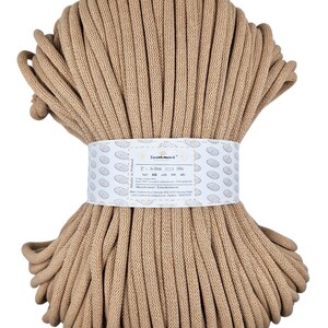 May include: A close-up of a beige cotton rope, wound into a ball. The rope is 5 mm thick and 100 meters long. The label reads "Sznurowanie" and "Made in Poland".