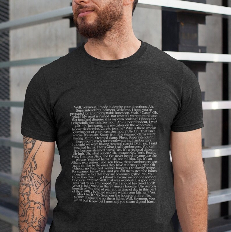 May include: A dark gray t-shirt with white text featuring a humorous conversation between two characters. The text includes the phrase "steamed hams" and references a regional dialect.