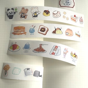 Puede incluir: Un conjunto de cinta washi colorida con ilustraciones de comida, animales y objetos. La cinta está impresa sobre un fondo blanco e incluye diseños como un panda, un oso, un pastel, un sándwich y una taza de café.