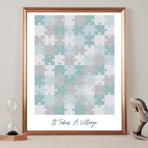May include: A framed print featuring a light blue and grey jigsaw puzzle design. The print includes the text "It Takes A Village" at the bottom.