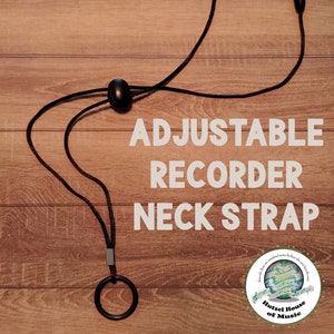 May include: Black adjustable recorder neck strap with a silver ring and black plastic adjusters. The strap is on a wood background. The text "ADJUSTABLE RECORDER NECK STRAP" is in white letters on the wood background. The text "Hutzell House of Music" is in green letters on a white circle with musical notes and a green background.