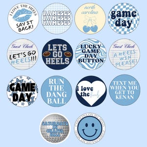 Puede incluir: Un conjunto de 12 botones redondos con varios diseños y textos relacionados con la Universidad de Carolina del Norte Tar Heels. Los botones presentan colores azul, blanco y amarillo con textos como "Game Day", "Let's Go Heels", "Run the Dang Ball" y "I Love the Heels".