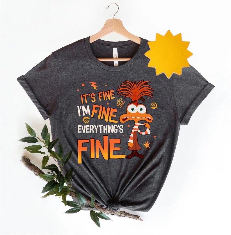 May include: A dark gray t-shirt with a cartoon character and the text "It's fine I'm fine Everything's fine".