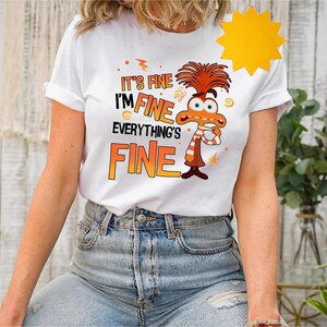 May include: White t-shirt with a cartoon character and the text "It's fine I'm fine everything's fine".