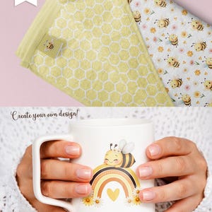 May include: A white ceramic mug with a cute cartoon bee sitting on a rainbow with a yellow heart. The bee has a flower crown and is smiling. The mug is surrounded by white daisies.