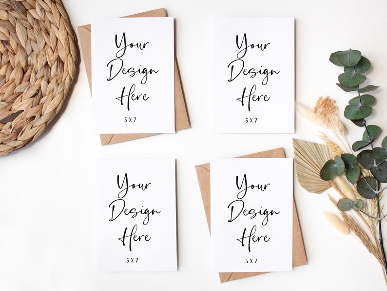 K&ouml;nnte beinhalten: Vier leere wei&szlig;e Karten mit braunen Umschl&auml;gen, jede Karte hat den Text "Your Design Here 5X7" darauf gedruckt. Die Karten sind quadratisch auf einer wei&szlig;en Oberfl&auml;che angeordnet. Im Hintergrund befinden sich getrocknete Blumen und gr&uuml;ne Bl&auml;tter.