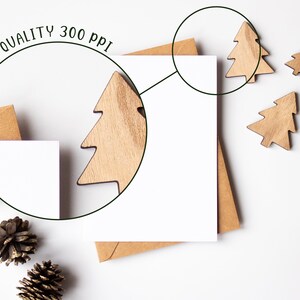 K&ouml;nnte beinhalten: Eine wei&szlig;e Karte mit einem braunen Umschlag auf wei&szlig;em Hintergrund. Um die Karte herum liegen verstreut Holz-Weihnachtsbaumschmuck. Der Text "HIGH QUALITY 300 PPI" ist in einem Kreis um die Karte geschrieben.
