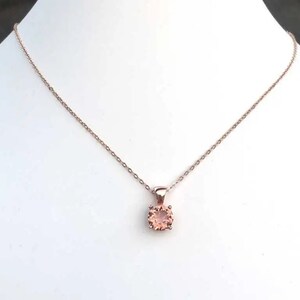 Puede incluir: Un delicado collar de cadena de oro rosa con un peque&ntilde;o colgante redondo de piedra preciosa de color melocot&oacute;n.