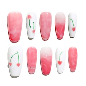 May include: Set of ten false nails with a pink and white ombre design. Some nails feature a cherry design with green stems and red cherries.