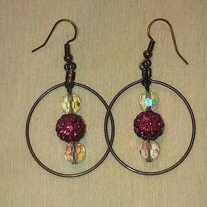 Pendientes de cuentas colgantes de color rosa brillante con detalles de bronce antiguo y cuentas de vidrio facetado transparente.
