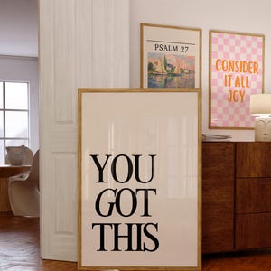 K&ouml;nnte beinhalten: Drei gerahmte Kunstdrucke mit inspirierenden Zitaten und Landschaftsszenen. Der gr&ouml;&szlig;te Druck lautet "YOU GOT THIS" in fetten schwarzen Buchstaben. Andere Drucke zeigen den Text "PSALM 27" und "CONSIDER IT ALL JOY" in einem rosa Karomuster.