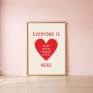 May include: A framed print with a gold border. The print features the words "EVERYONE IS" at the top, a red heart in the center with the words "WELCOME, IMPORTANT, ENCOURAGED, RESPECTED," and the word "HERE" at the bottom.