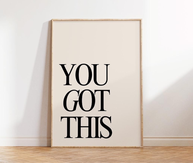 K&ouml;nnte beinhalten: Ein gerahmter Druck mit den Worten "YOU GOT THIS" in fetten schwarzen Buchstaben. Der Hintergrund ist hellbeige und der Rahmen hellbraun. Der Druck lehnt an einer wei&szlig;en Wand.