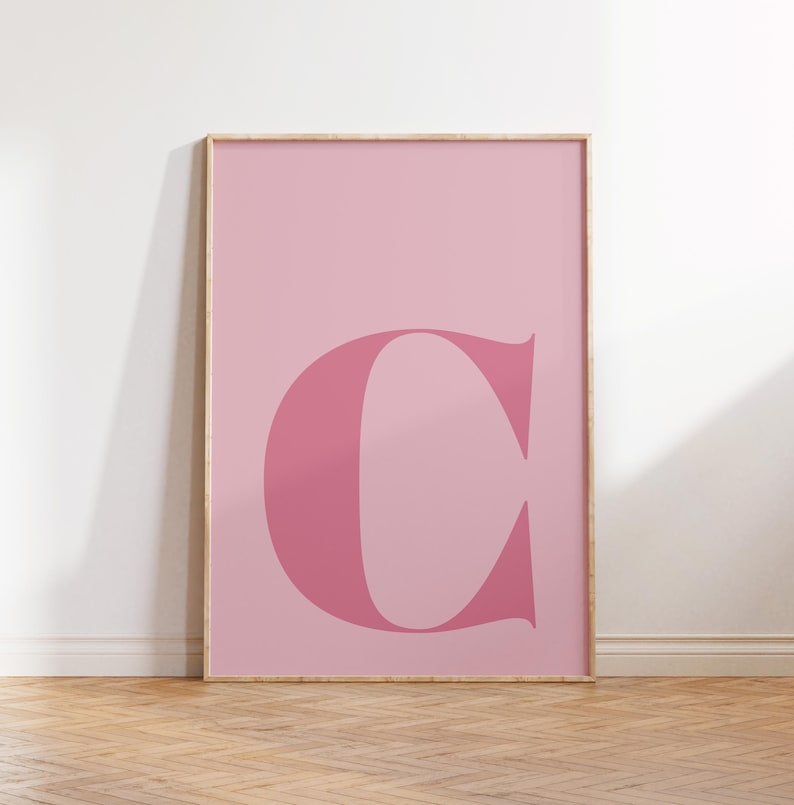 Puede incluir: Un p&oacute;ster rosa enmarcado con una gran letra "C" rosa y audaz en el centro.