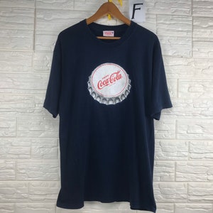 Op de afbeelding: Een marineblauw T-shirt met een witte Coca-Cola-flessendoppenprint.