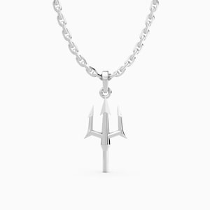 Puede incluir: Un collar con colgante plateado con un diseño de tridente. El tridente, una lanza de tres puntas, cuelga de una cadena. El collar está hecho de un material metálico brillante. El fondo es blanco.