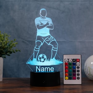 以下が含まれることがあります： サッカー選手のシルエットが特徴の青色LEDランプ。ベースには「Name」の文字。カラーオプション付きのリモコンが付属。選手は背番号10のユニフォームを着ています。