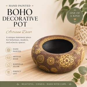 May include: A round, low-profile decorative pot with a dark brown, textured exterior featuring hand-painted gold mandala and floral patterns. The interior of the pot is smooth and black. The text on the image reads: HAND PAINTED BOHO DECORATIVE POT.